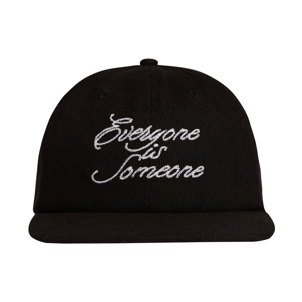 Black corduroy hat with embroidered white cursive script that reads Everyone is Someone
